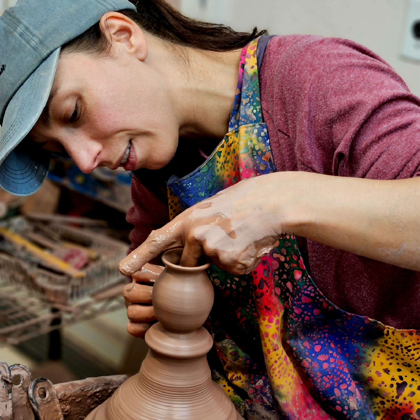 Leslie of The Mud Place throwing Mommy Pot mini vases on a pottery wheel off the hump