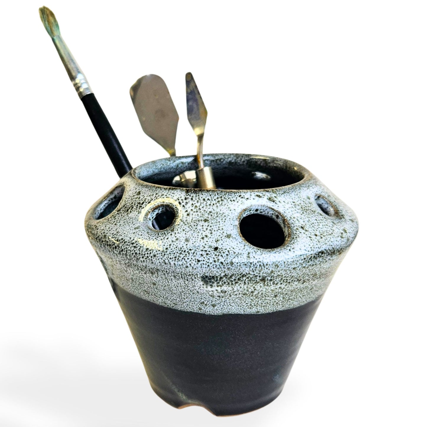 Handmade ceramic pottery tool caddy in black and white speckled glaze, featuring a flared cone shape with multiple round openings around the rim for organizing art supplies, pens, pencils, brushes, or scissors. Unique handcrafted desk organizer, perfect for artists, crafters, or pottery lovers.