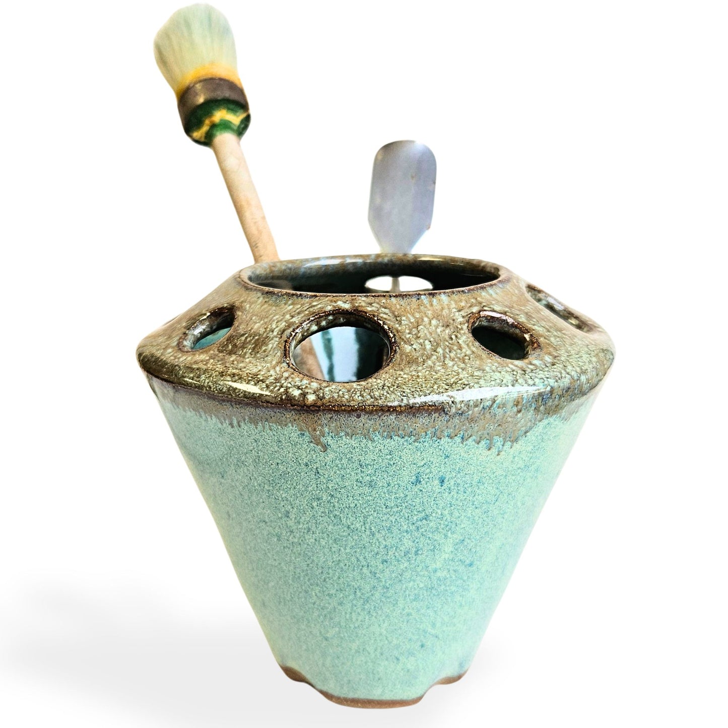 Handmade ceramic pottery tool caddy in green and brown speckled glaze, featuring a flared cone shape with multiple round openings around the rim for organizing art supplies, pens, pencils, brushes, or scissors. Unique handcrafted desk organizer, perfect for artists, crafters, or pottery lovers.