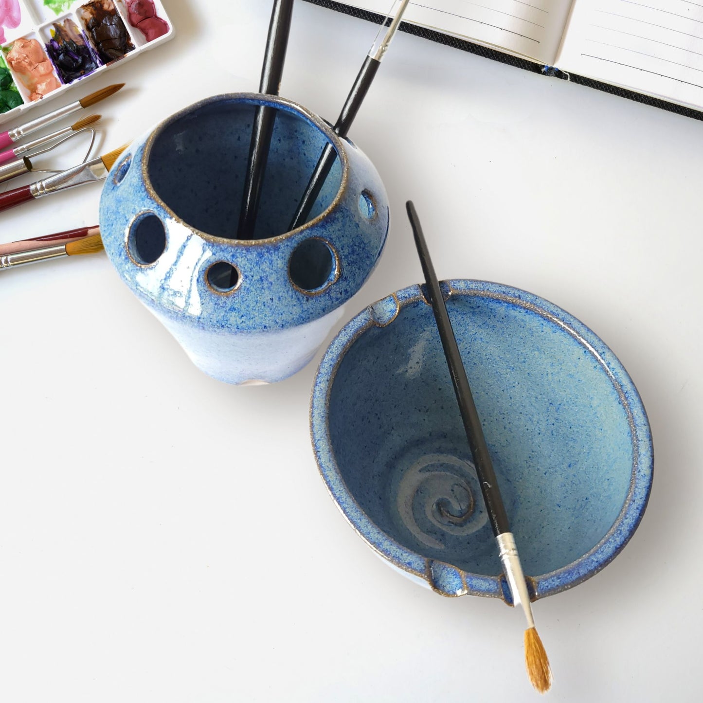 Handmade ceramic watercolor painting set with matching brush rinse bowl and coordinating pottery tool caddy. Features built-in brush rests, multiple tool slots for pens, pencils, or paintbrushes, and durable dishwasher-safe stoneware. Perfect for artists, painters, and crafters.