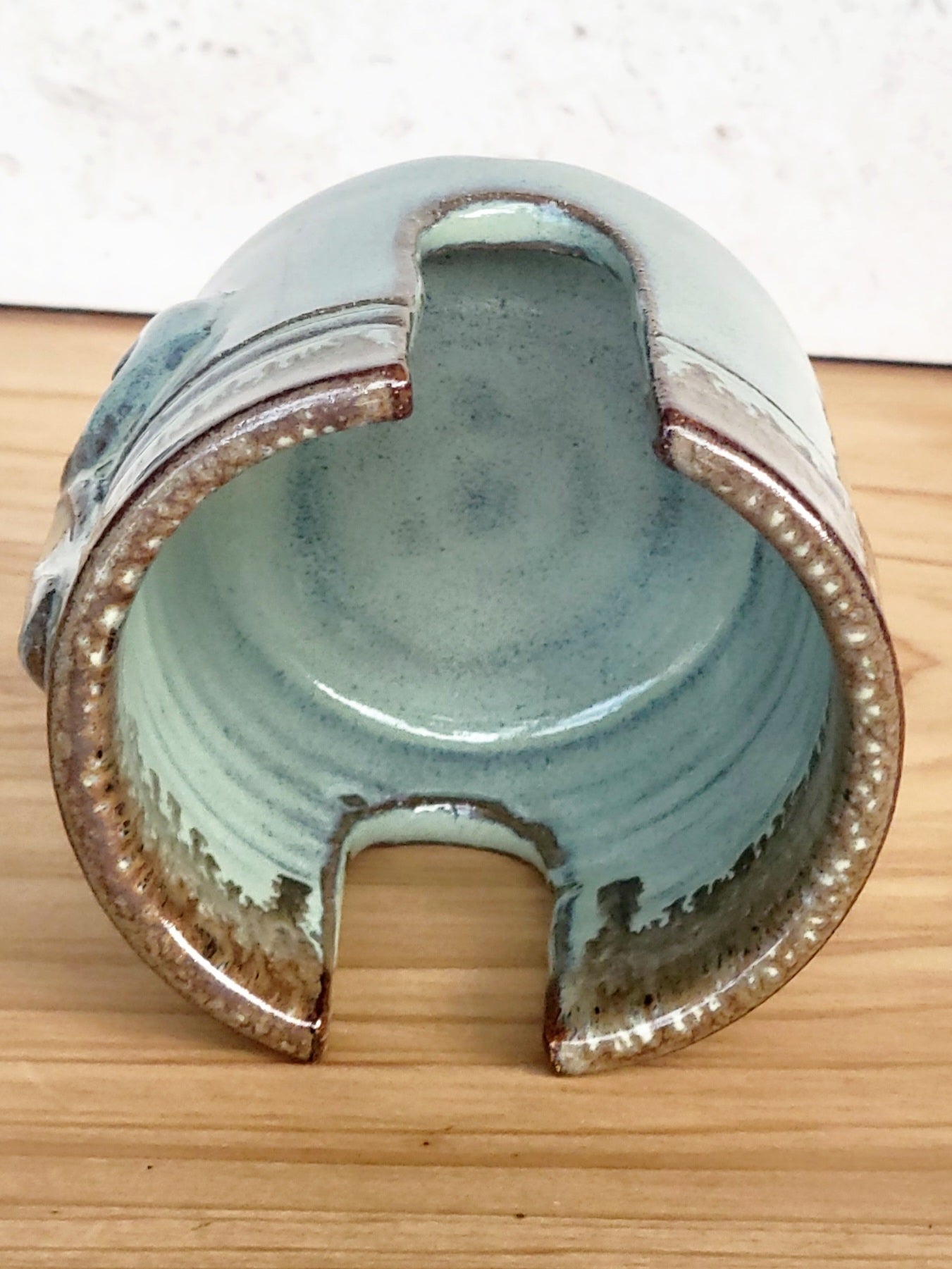 Insideview of ceramic green sponge keeper with a decorative fleur-de-lis design holding a crochet cotton yarn scrubber sponge. Perfect for kitchen counter organization. 