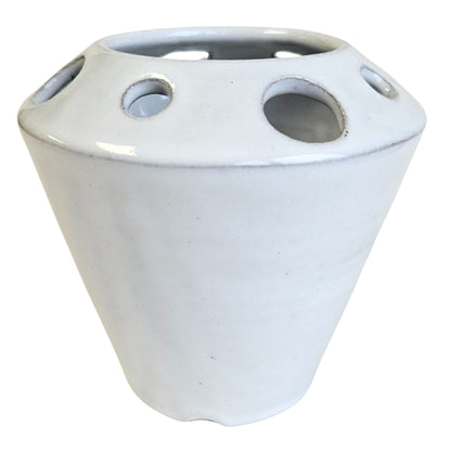 White ceramic circular storage container with various sized slots for craft tools, paint brushes, crochet hooks and knitting needles on a white background