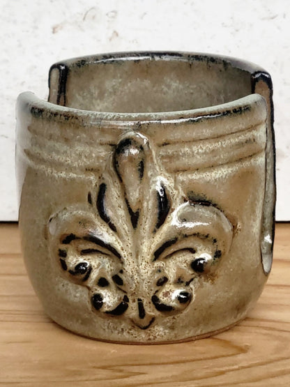Side view of handmade artisan bronze ceramic sponge holder with embossed fleur-de-lis design, can hold a cotton crochet scrubber sponge. Eco-friendly kitchen countertop accessory perfect for storing crochet scrubbers, dish sponges, and sink cleaning essentials.