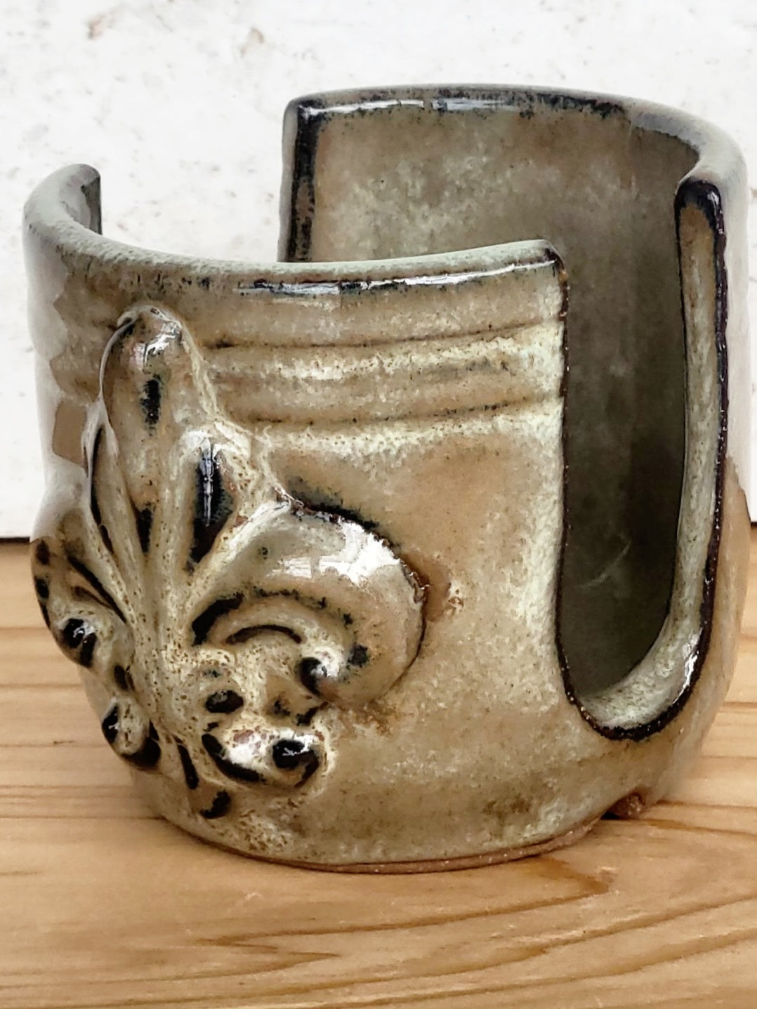 Side view of handmade artisan bronze ceramic sponge holder with embossed fleur-de-lis design, can hold a cotton crochet scrubber sponge. Eco-friendly kitchen countertop accessory perfect for storing crochet scrubbers, dish sponges, and sink cleaning essentials.