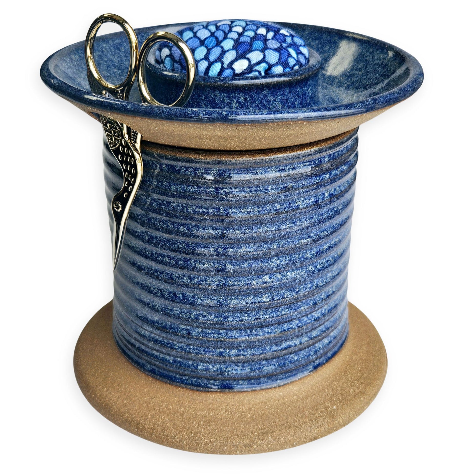 Handmade ceramic sewing caddy shaped like an oversized spool, in vibrant blue glazes, with a fabric-topped pincushion, scissors slot, and removable lid for storage. mermaid pincushion fabric