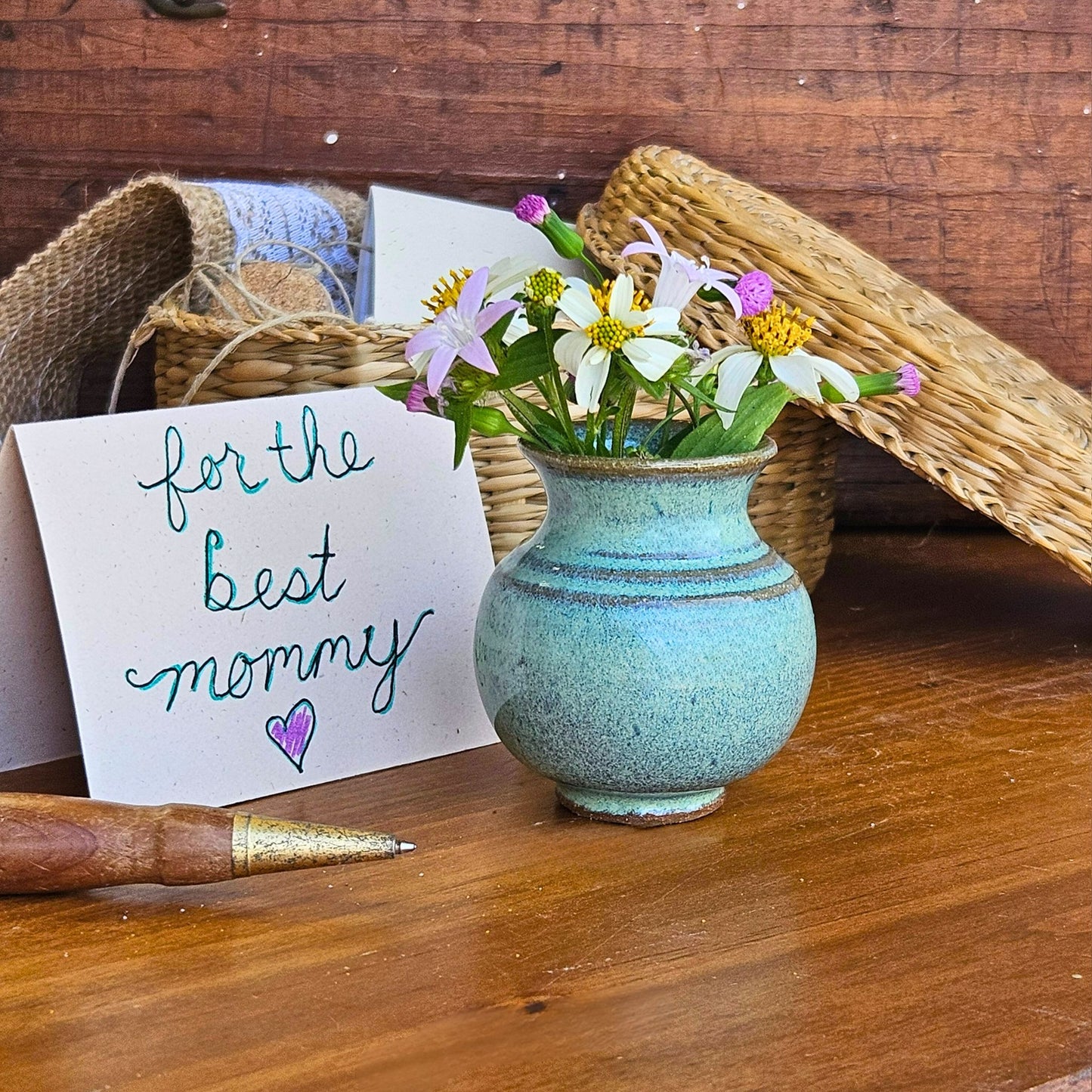 Handmade ceramic Mommy Pot in soft green glaze, featuring a wildflower bouquet and "for the best mommy" card – a meaningful keepsake for Mother's Day, birthdays, or thinking-of-you gifts.