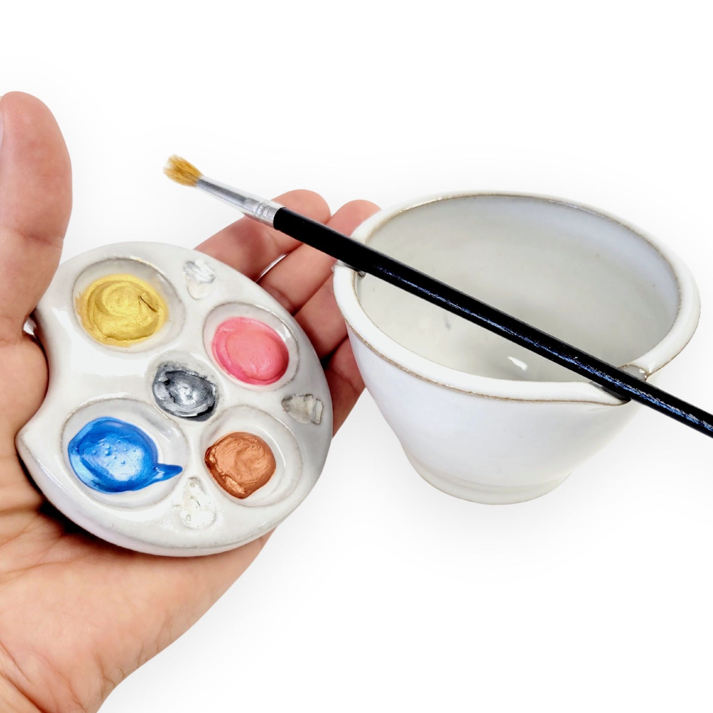 Handmade stoneware watercolor set with crescent paint palette and matching brush rinse bowl. Includes 5 wells, textured areas, and built-in brush rest. Dishwasher safe and portable.
