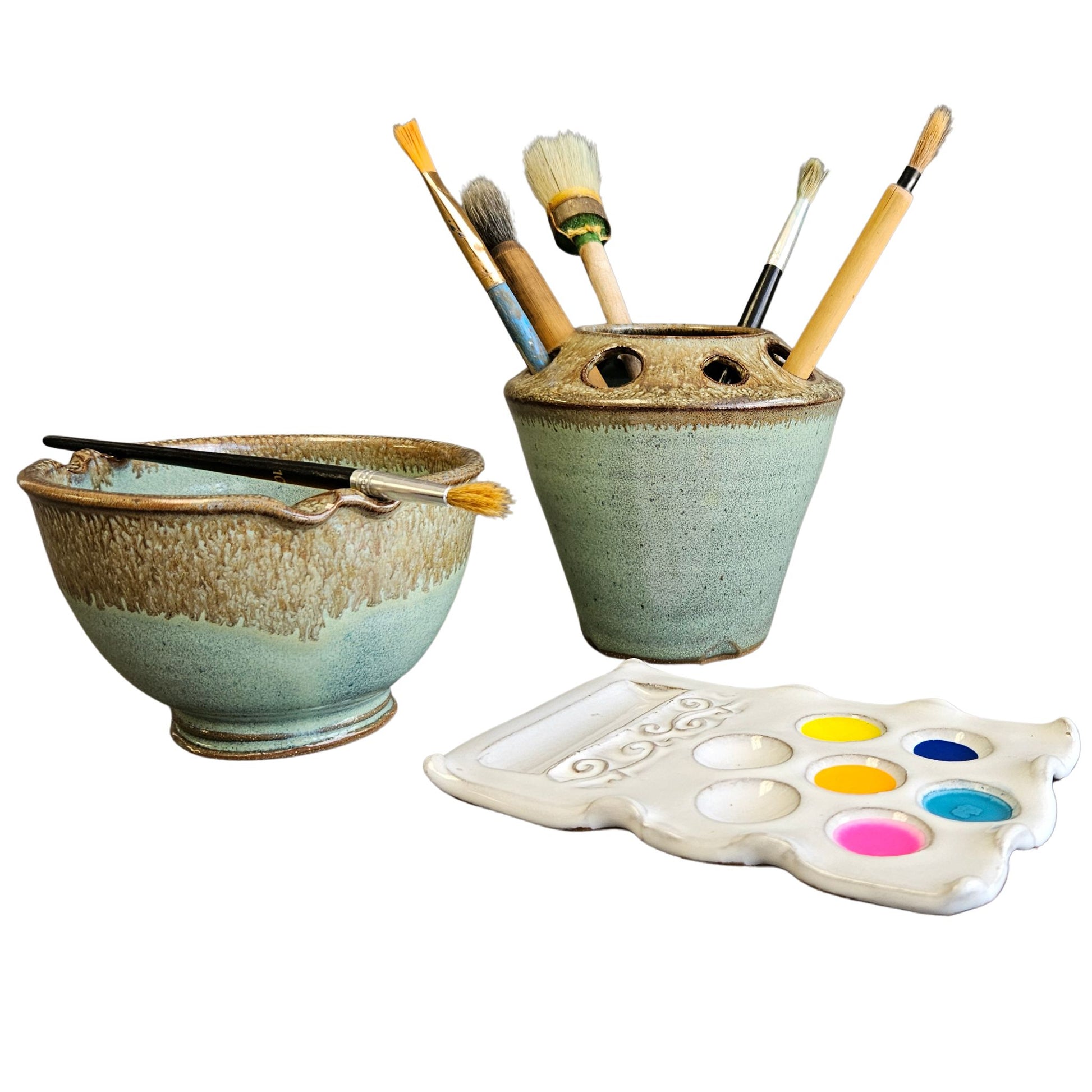 Handmade 3-piece ceramic professional artist set including a green and brown speckled rinse bowl with incorporated brush rests, matching brush organizer jar filled with paintbrushes, and a white ceramic paint palette with colorful paints.
