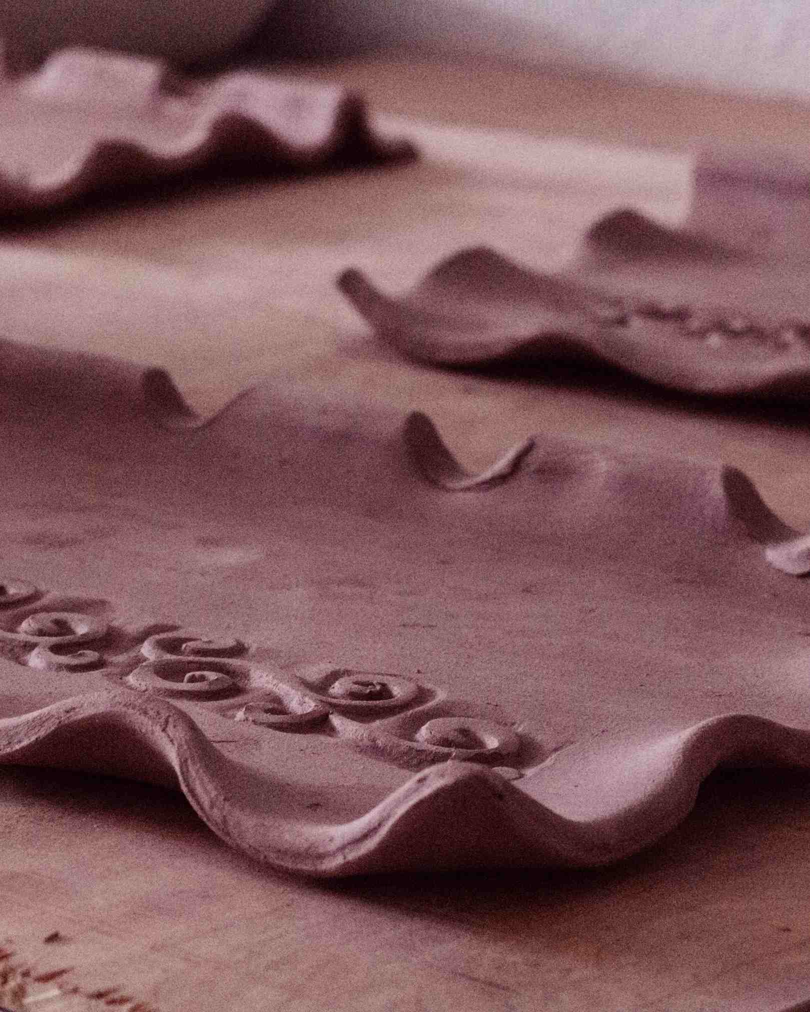 process shot of clay being formed into shapes with swirl design