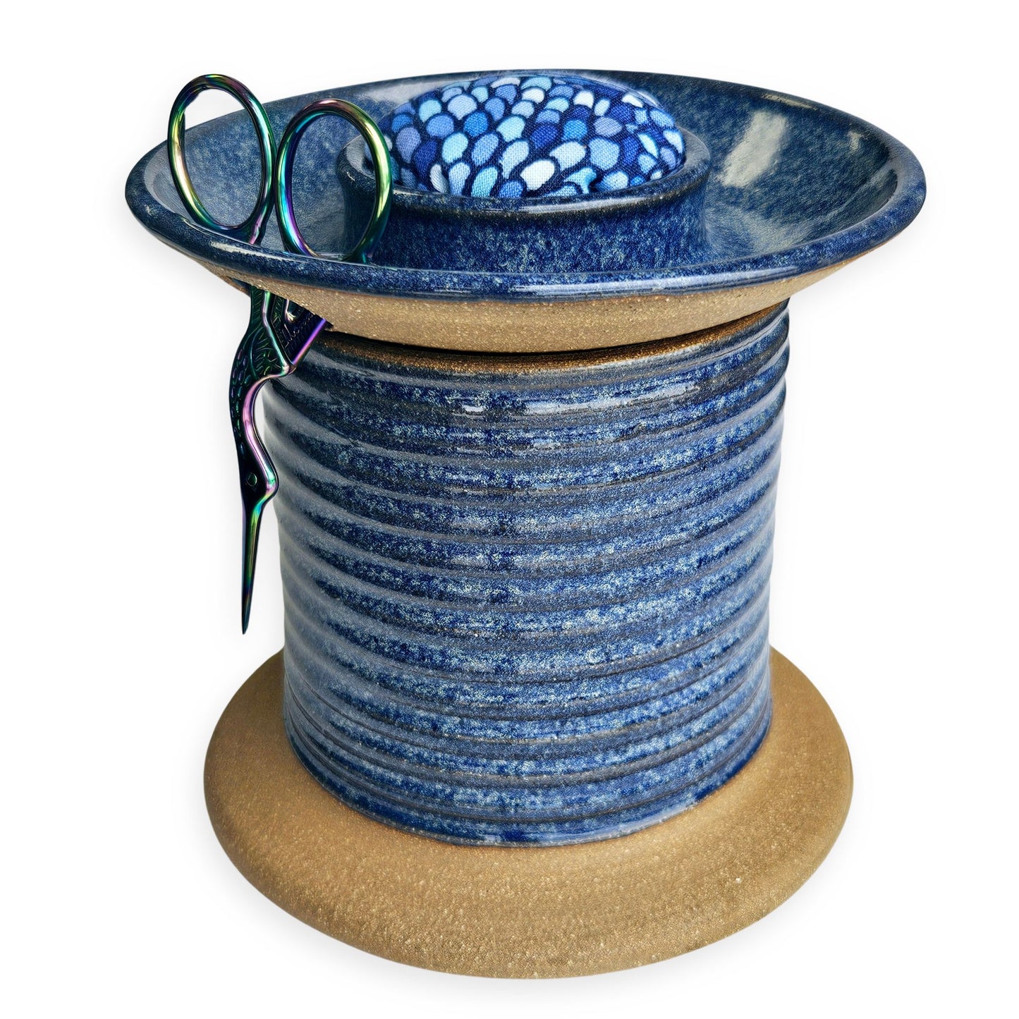 Handmade ceramic sewing caddy shaped like an oversized spool, in vibrant blue glaze, with a fabric-topped pincushion, scissors slot, and removable lid for storage. mermaid pincushion fabric