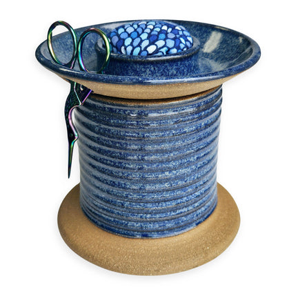 Handmade ceramic sewing caddy shaped like an oversized spool, in vibrant blue glaze, with a fabric-topped pincushion, scissors slot, and removable lid for storage. mermaid pincushion fabric