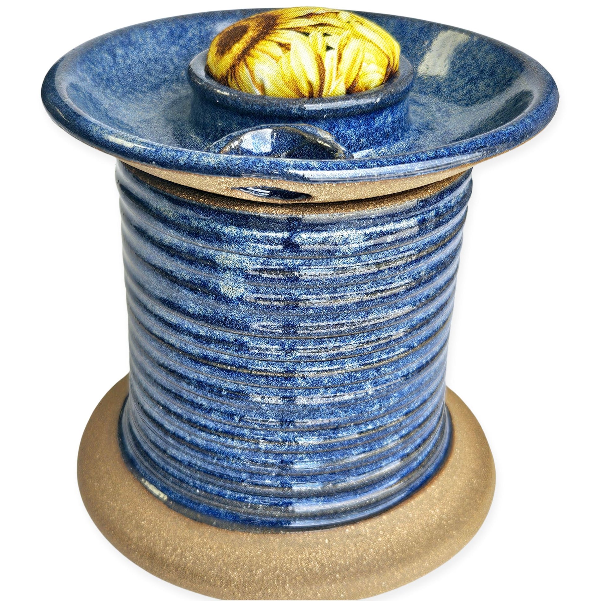 Handmade ceramic sewing caddy shaped like an oversized spool, in vibrant blue glazes, with a fabric-topped pincushion, scissors slot, and removable lid for storage. sunflower pincushion fabric