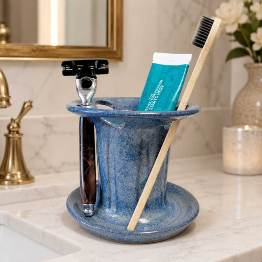 Organized bathroom countertop with blue toothbrush and toothpaste holder plus dedicated shaving razor storage