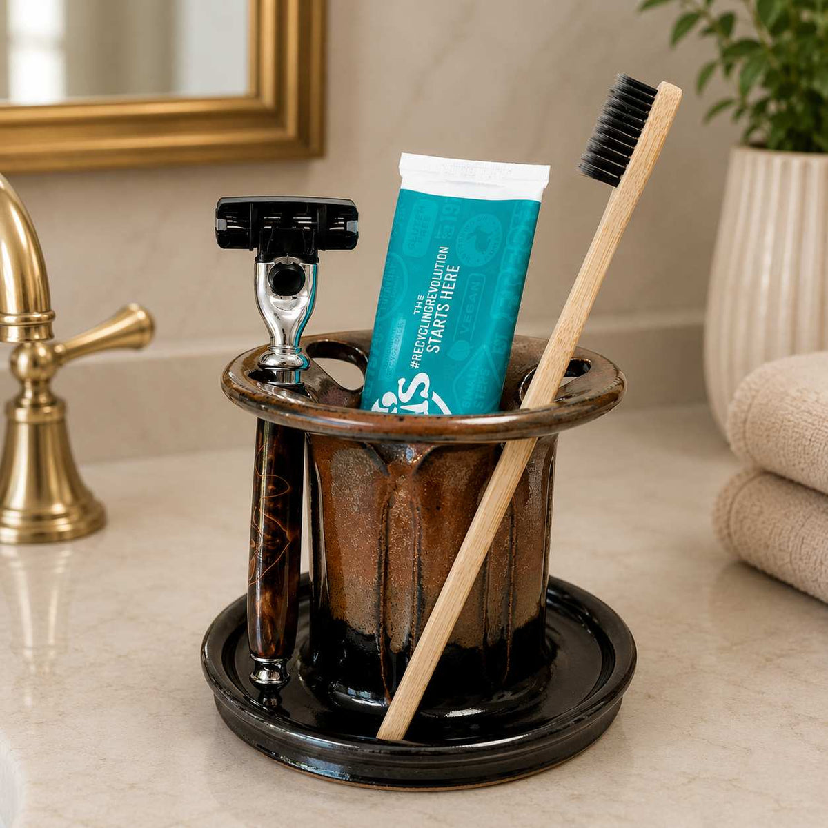 Organized bathroom vanity with brown and black toothbrush holder, toothpaste storage and shaving razor holder