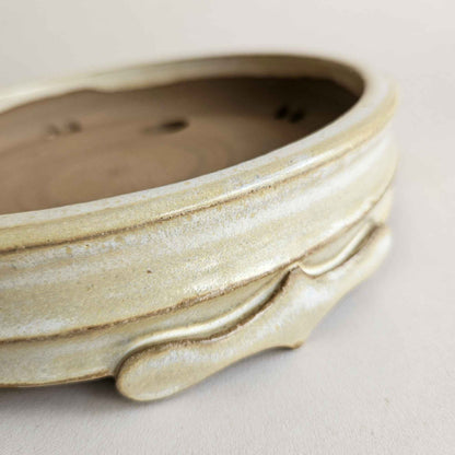 Close-up of the four pointed bonsai pot feet with dramatic hand-shaped curves and decorative details.