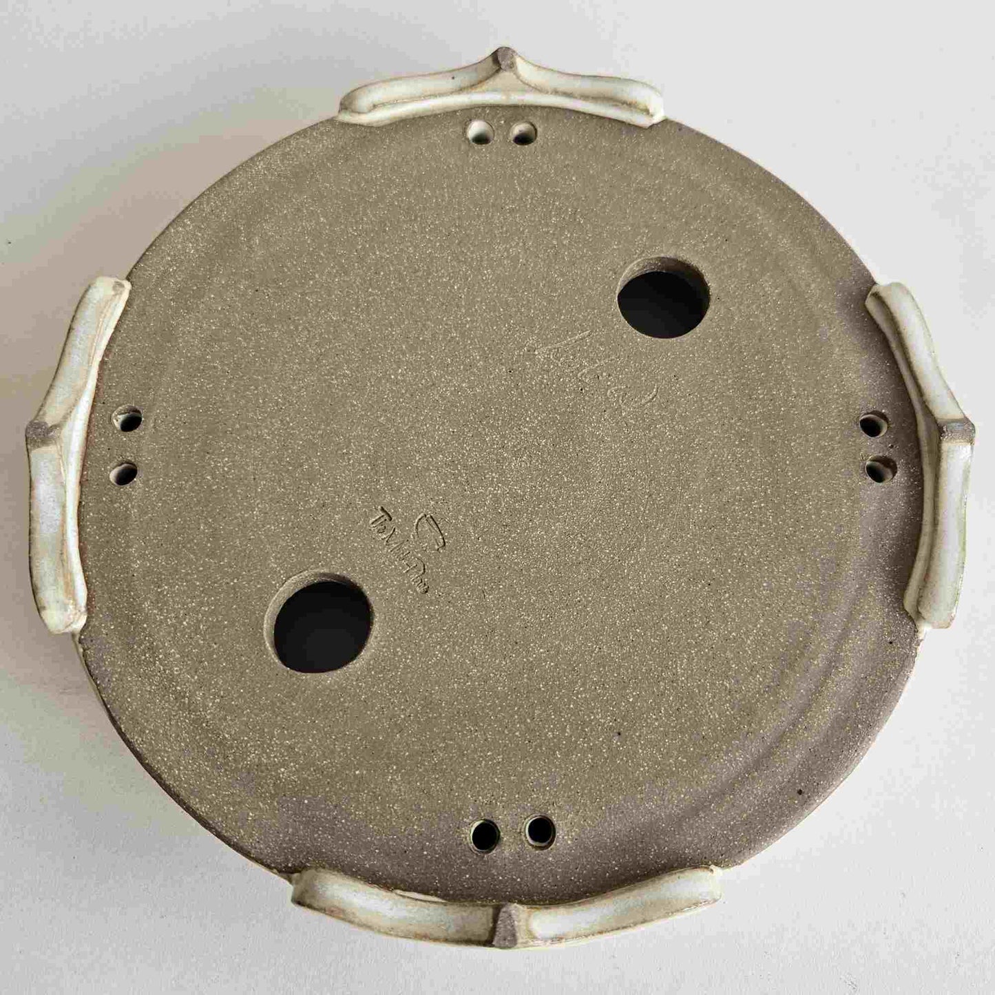 bottom of round footed bonsai pot.