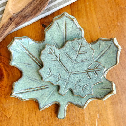 Handmade ceramic maple leaf spoon rest in hand showing glaze texture and leaf details