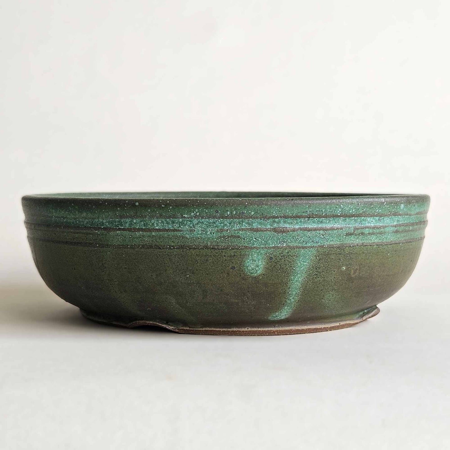 Matte bonsai pot finish shifting from dark brown and olive to turquoise green.