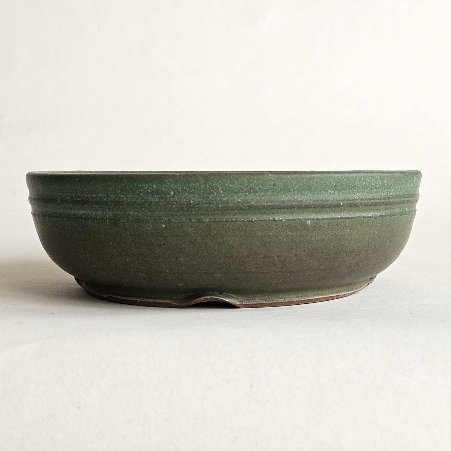 Round green shohin bonsai pot with a straight rim, low profile, and matte olive-to-turquoise finish.