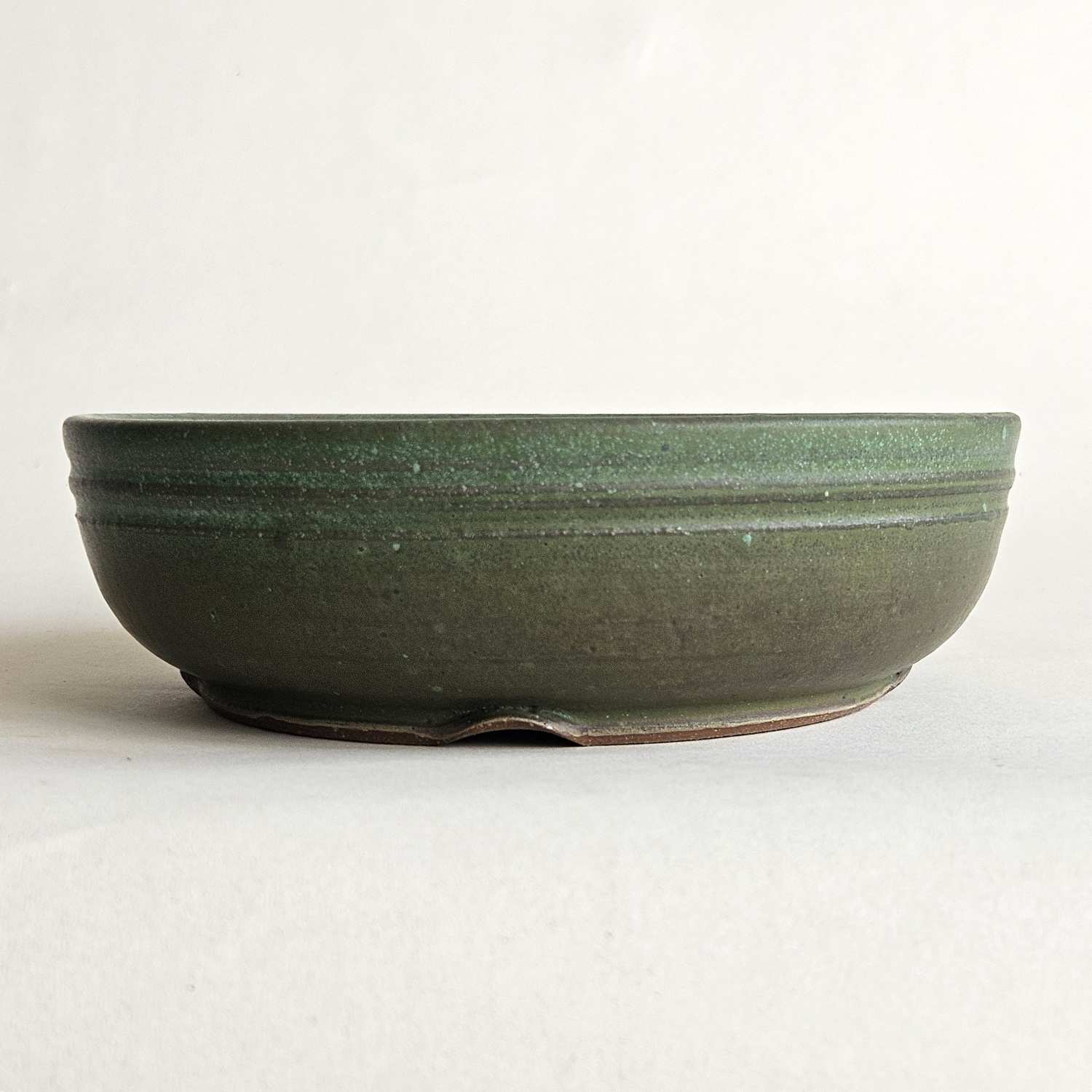 Round green shohin bonsai pot with a straight rim, low profile, and matte olive-to-turquoise finish.