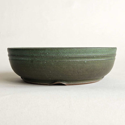 Round green shohin bonsai pot with a straight rim, low profile, and matte olive-to-turquoise finish.