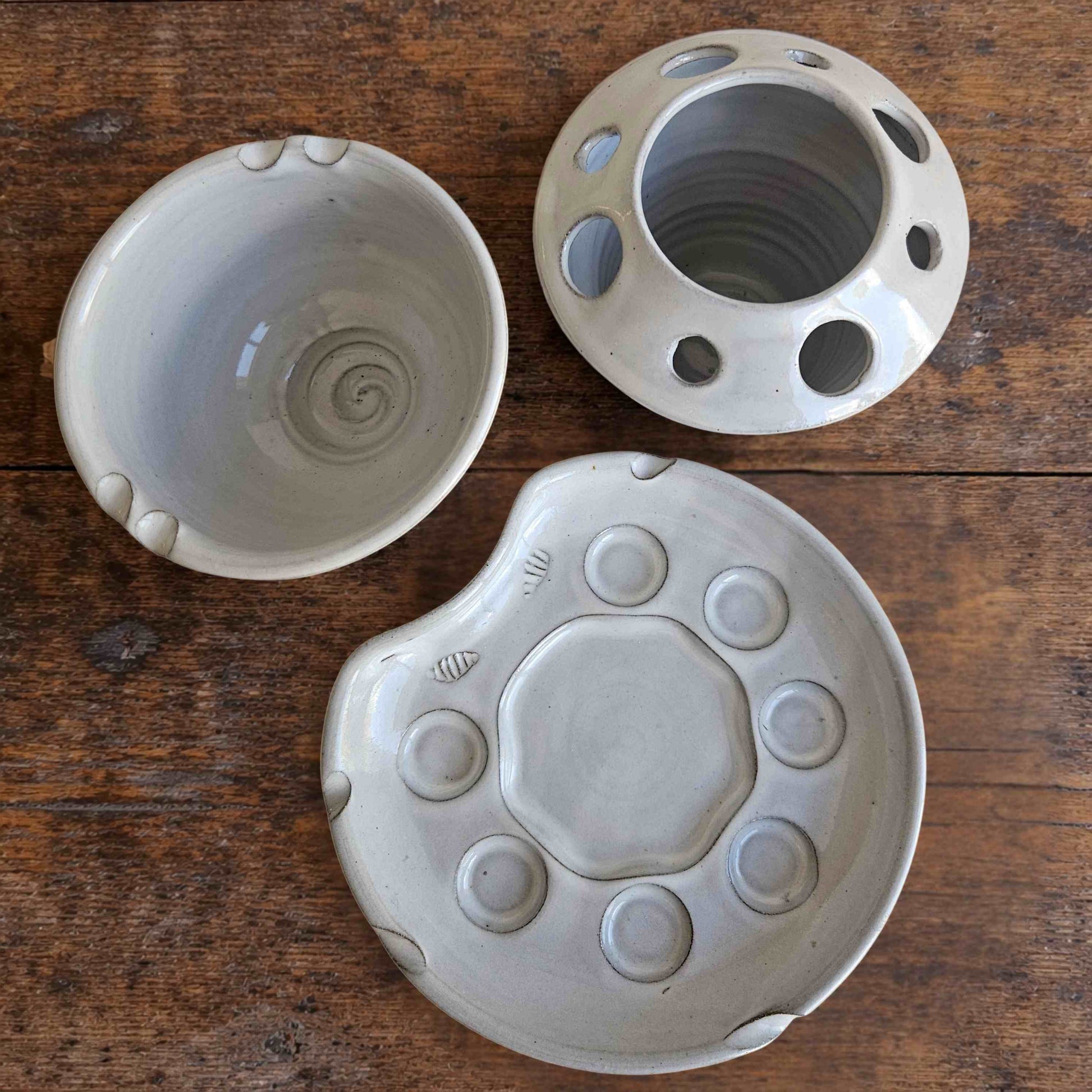 Top view of handmade ceramic paint palette set including palette, brush caddy, and rinse bowl in white glaze.