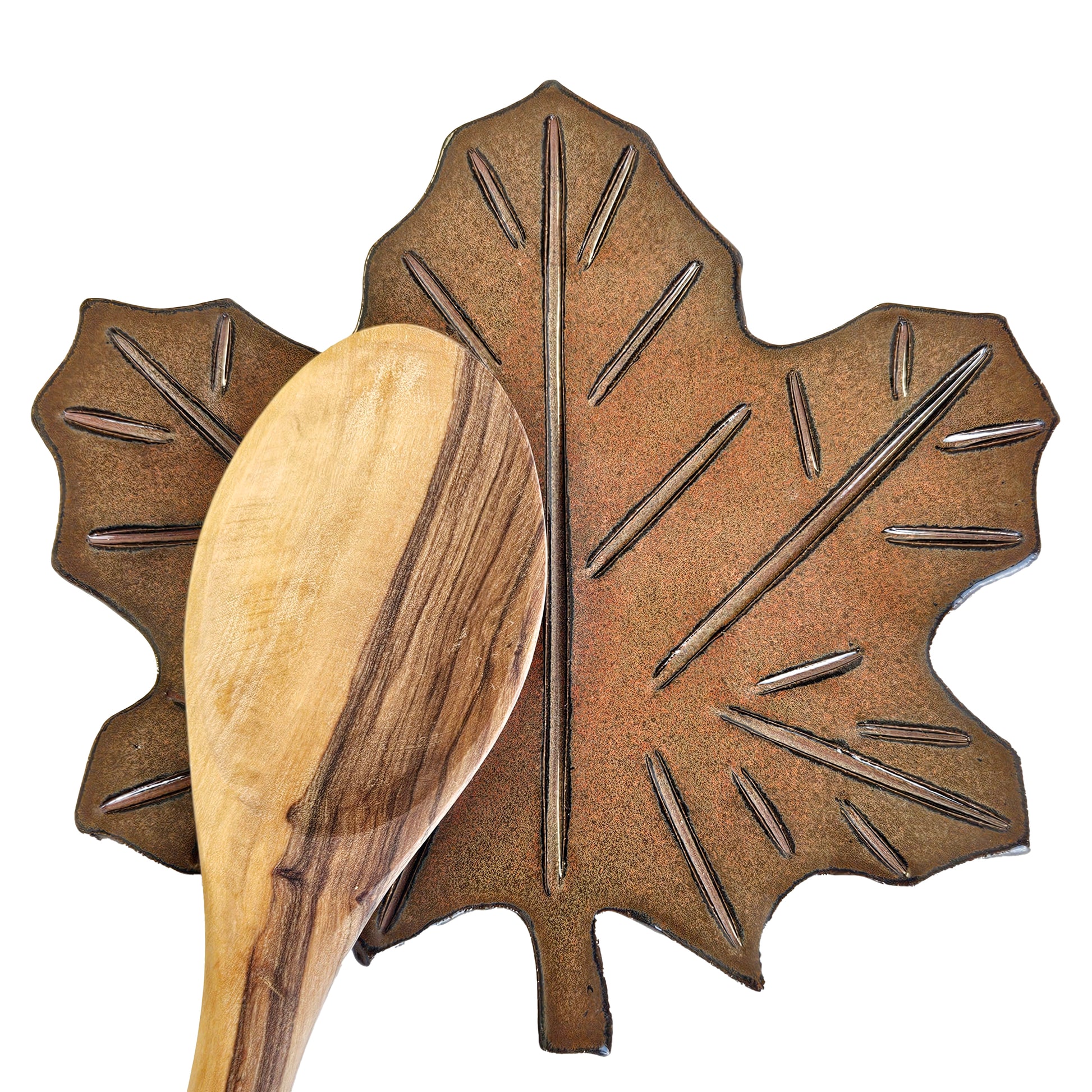 Rust-colored maple leaf pottery spoon rest holding a wooden cooking spoon – handmade fall kitchen accessory