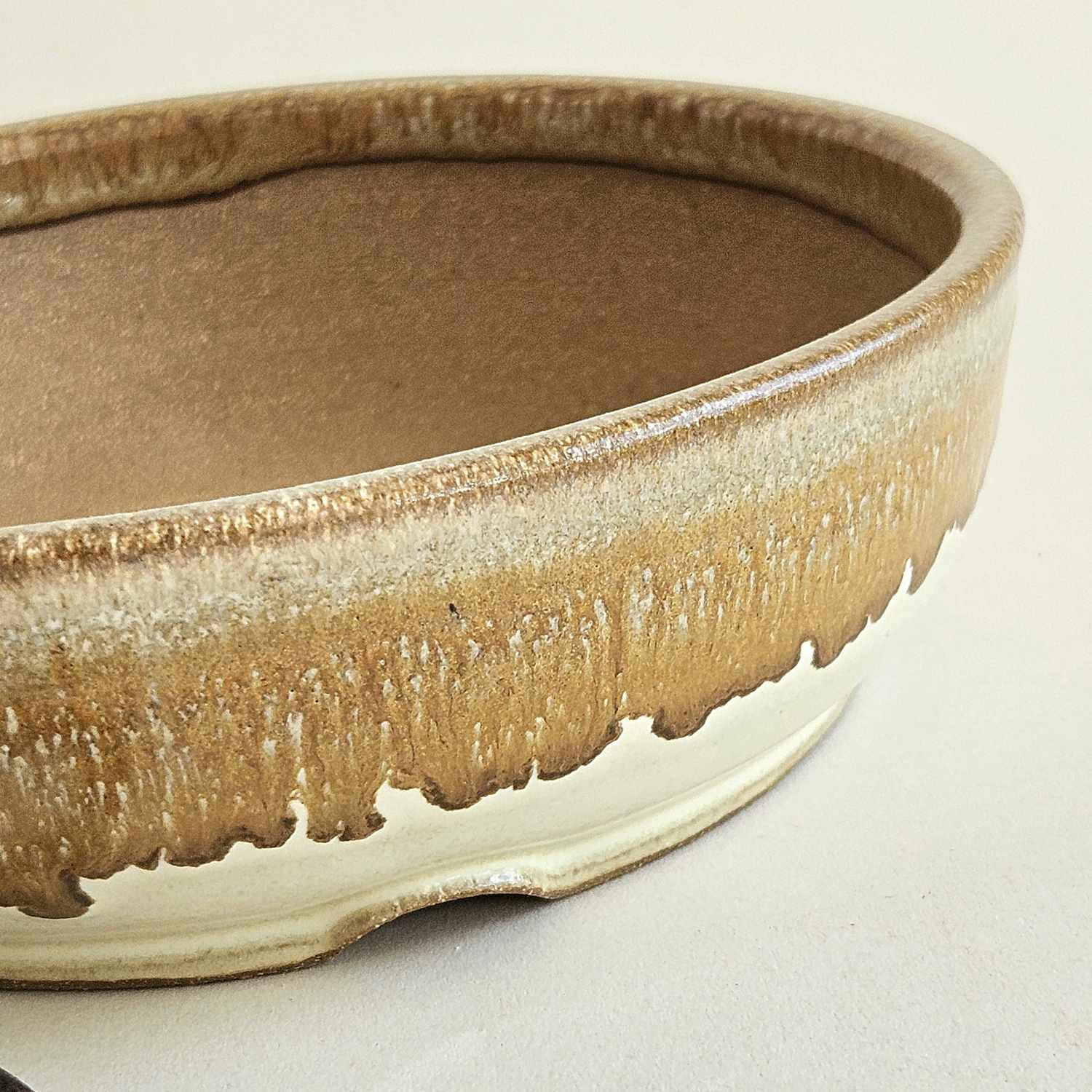 Low round bonsai pot with a satin yellow finish, flowing bronze details, and a straight rim.