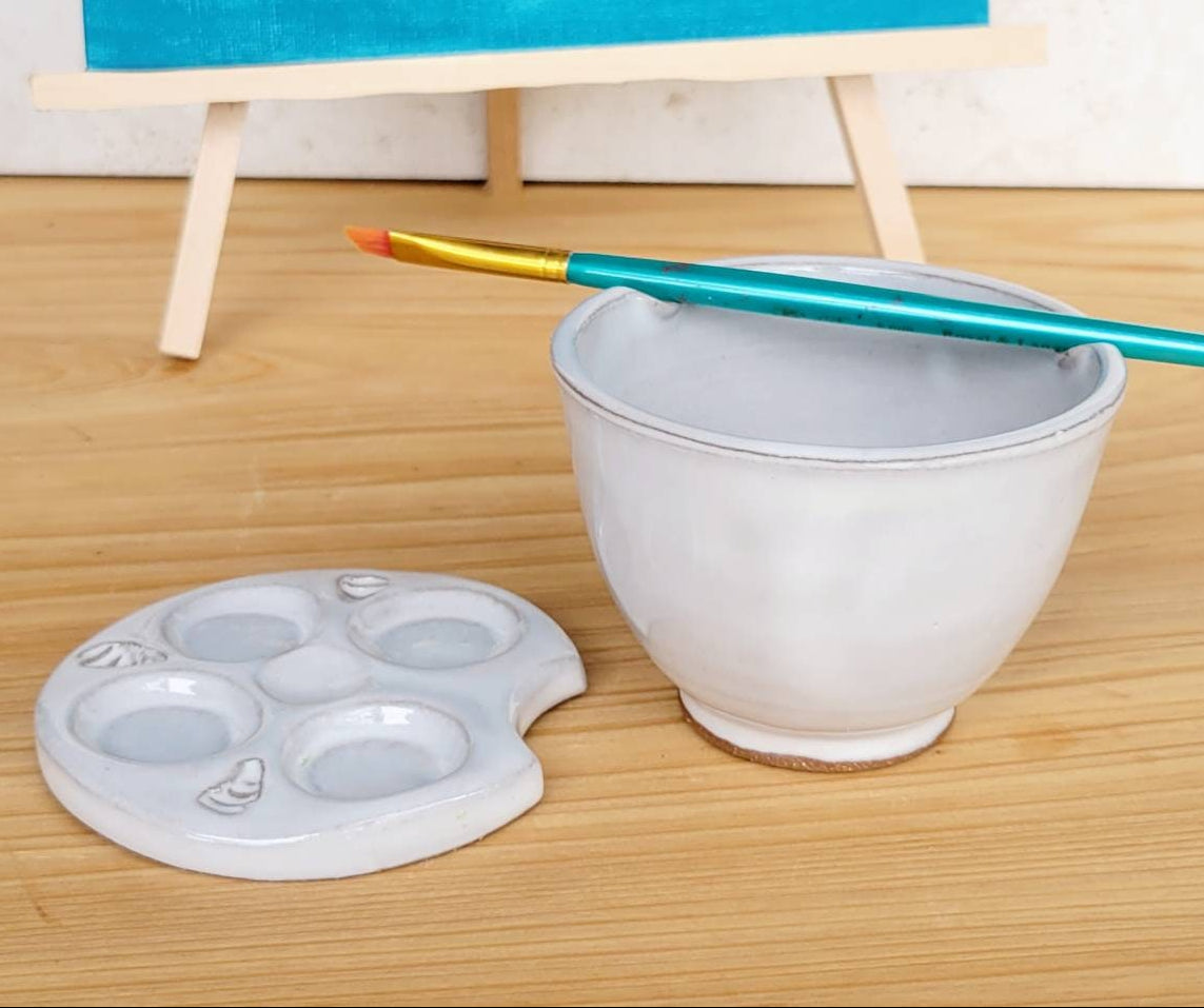 Handmade white pottery watercolor palette and bowl set with brush rest, ideal for studio or travel painting.